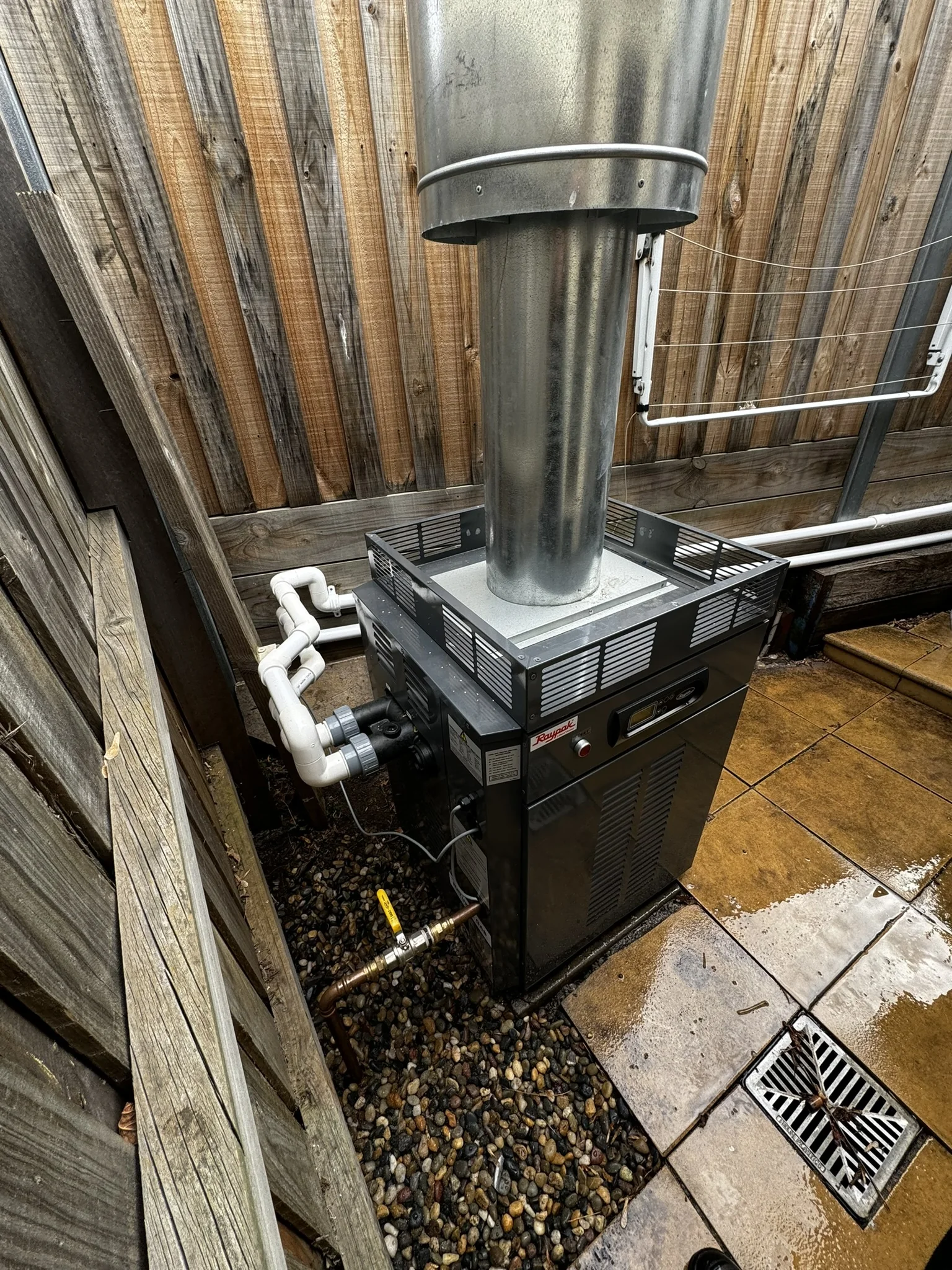 Compact pool equipment installation beside a timber fence